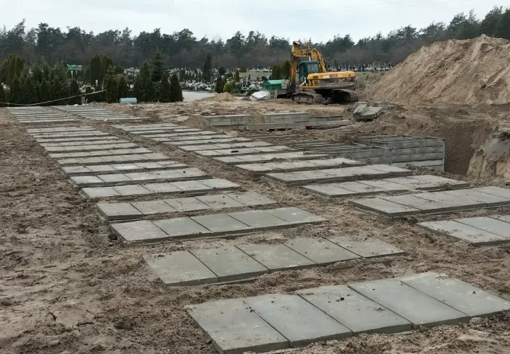 Przygotowanie terenu na cmentarzu, gdzie układane są płyty betonowe. Zastanawiasz się, ile kosztuje fundament pod pomnik? Tu widać początek prac.
