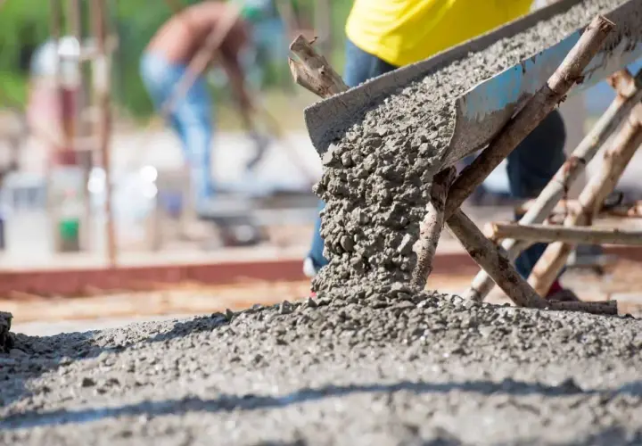 Beton wylewany z rynny na placu budowy. Kluczowe dla prawidłowego wykonania prac jest to, jak obliczyć ilość betonu na wylewkę.