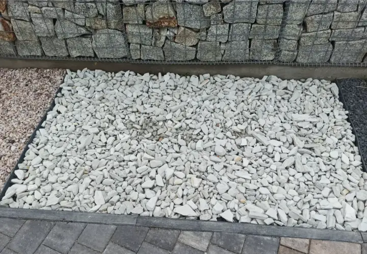 Jasnoszary grys idealny na podjazd. Obok kamienie w kolorze różowym i ciemnoszarym.