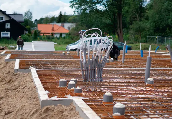 Budowa fundamentów domu: zbrojenie, rury i izolacja.