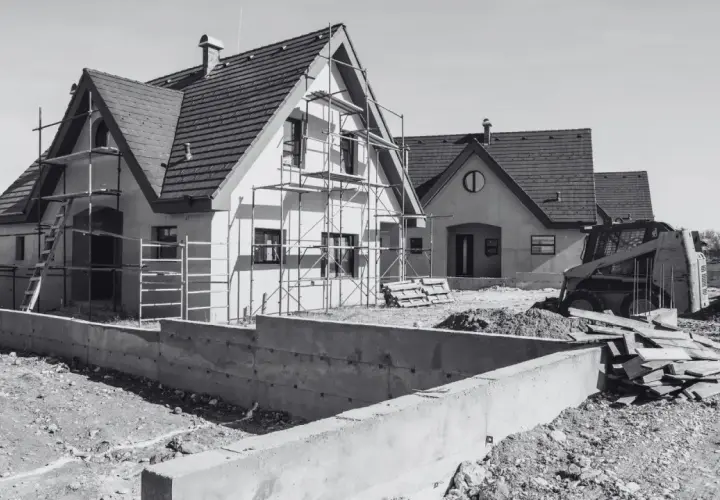 Budowa domów w toku. Scena pokazuje postęp prac, jak przenieść pozwolenie na budowę, gdy domy są w stanie surowym, z rusztowaniami i koparką.