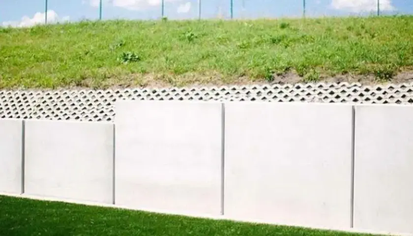 Nowoczesny mur oporowy z betonowych płyt i ażurowej podmurówki. Czy mur oporowy wymaga pozwolenia na budowę?